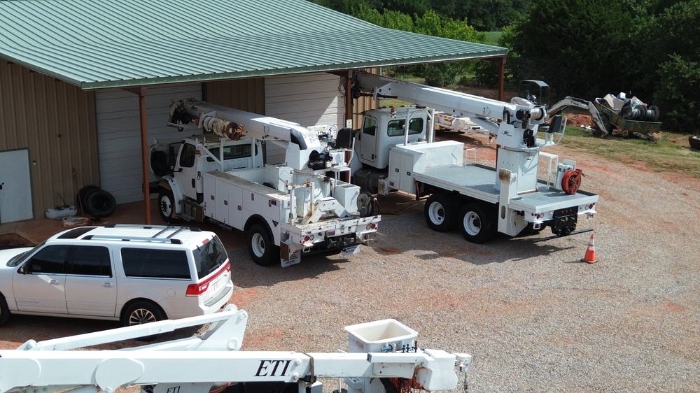 Digger derrick and bucket trucks lined up at the SS Utility Group yard